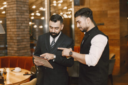 Serveur discutant avec son manager dans un restaurant, illustrant les règles sociales applicables aux salariés du secteur HCR.